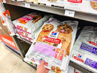 person grabbing a large bag of hill's science diet dog food off a shelf