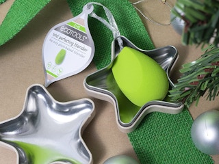 An EcoTools total perfecting blender in a star-shaped tin near some Christmas decor.