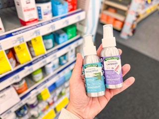 hand holding two nature's truth essential oil mists in cvs
