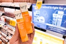 hand holding 2 no7 radiance eye creams in front of a no7 skincare aisle display