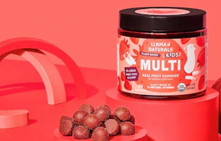 a jar of vitamins on a red display next to gummies 