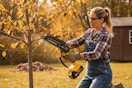 a woman using a mini chainsaw on a tree