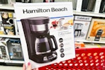 hand holding hamilton beach coffee maker over target cart