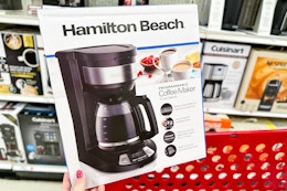 hand holding hamilton beach coffee maker over target cart