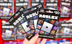 hand holding Roblox gift cards in front of the gift card area at Target