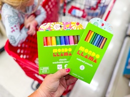 hand holding mondo llama crayons in front of a target shelf