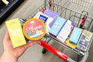 person holding bubble and tree hut skincare over a cart with more skincare products in it
