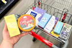 person holding bubble and tree hut skincare over a cart with more skincare products in it