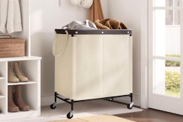 StorageWorks Laundry Hamper 2 Section full of clothes in a mud room.