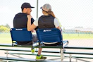 Lifestyle image of the Ozark Trail Stadium Seat being used by a couple at a sports game 