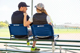 Lifestyle image of the Ozark Trail Stadium Seat being used by a couple at a sports game 