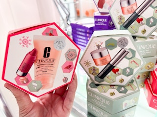 someone holding a clinique small makeup gift set