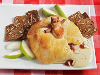 raspberry baked brie with almonds on plate with apples and crackers