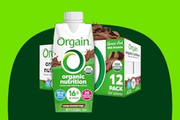 A 12-pack of Orgain Organic Protein Shakes with 16g protein in creamy chocolate fudge flavor with one large carton in front of the case.