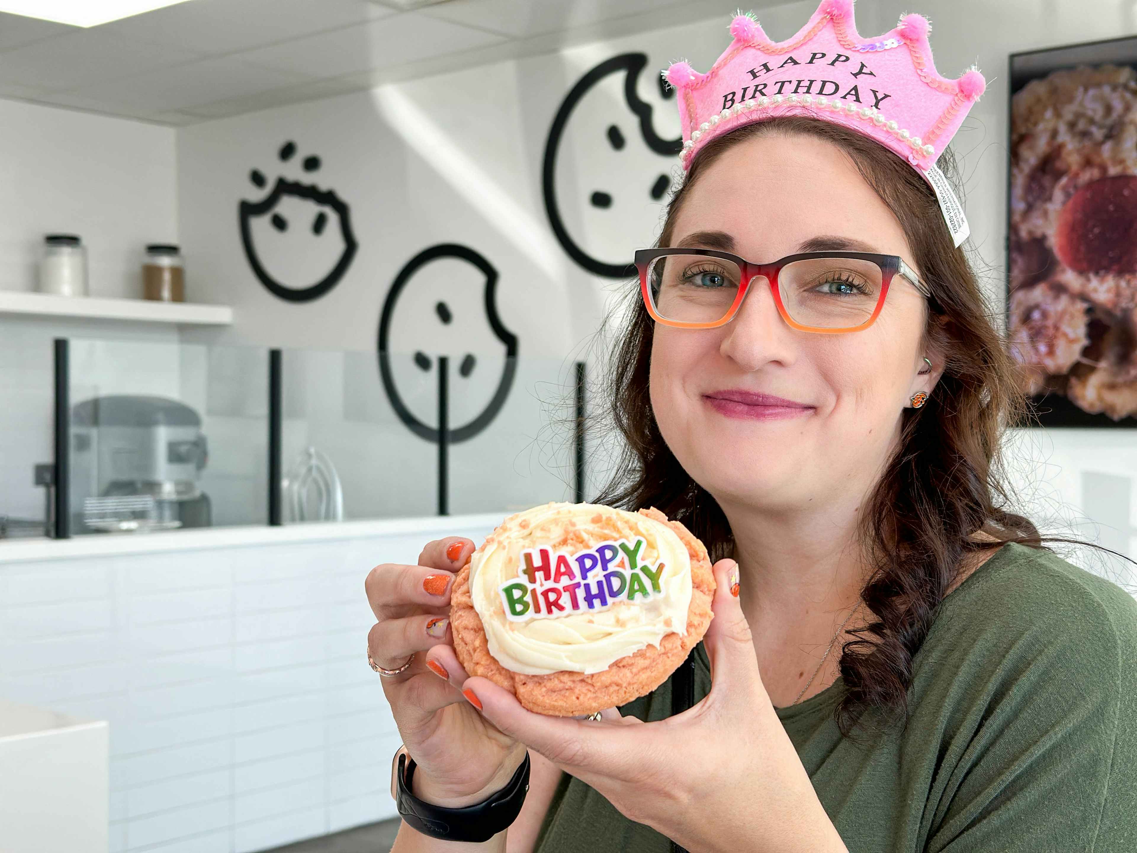 woman holding a crumbl birthday cookie in store