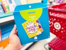 hand holding a mondo llama you & me craft book in front of a target cart