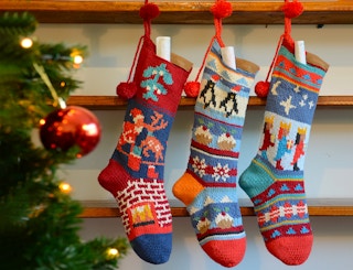 Chunki Chilli Personalized Hand Knit Christmas Stockings hanging by a Christmas tree
