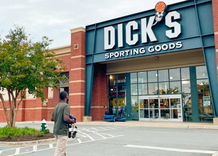 Person walking to Dick's Sporting Goods with items in hand