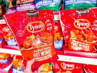 hand holding a bag of tyson wings