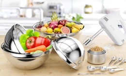 vegetables in metal mixing bowl next to measuring cups and a hand blender