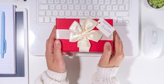 A person putting a secret santa present down on a desk
