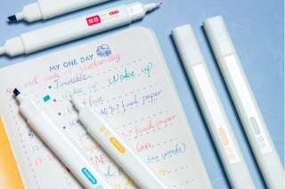 Double-tip highlighters on a notebook