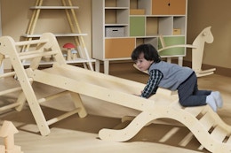 kid using a montessori pikler triangle climber set