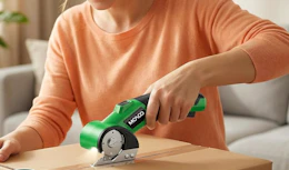 a person using electronic scissors on cardboard