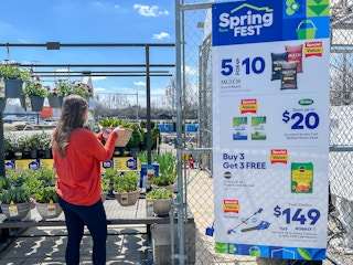 a person looking at a plant outside of a lowes
