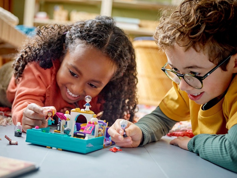 Two kids playing with a storybook Lego set