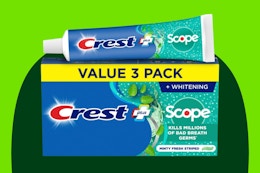Crest + Scope Toothpaste on a green background.