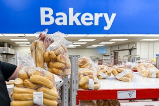 Someone holding up bags of fresh bread in the Sam's Club bakery