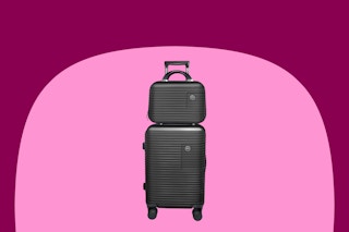 A black 14-inch small case is stacked on a 20-inch suitcase. Both are hardside.