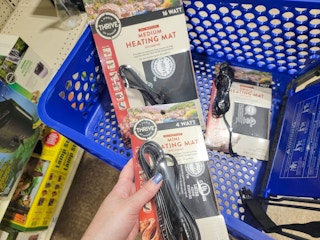 hand holding a reptile heating mat over a cart