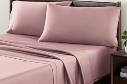 Lifestyle image of the Allswell 4-piece sheet set in the color "Mauve" on a bed in room setting