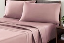 Lifestyle image of the Allswell 4-piece sheet set in the color "Mauve" on a bed in room setting