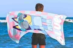 Lifestyle image of the kids' Bluey towel being used at the beach