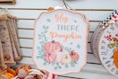 hand touching a hey there pumpkin sign at dollar tree