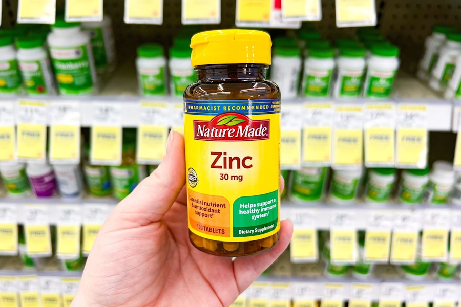 person holding a bottle of zinc tablets