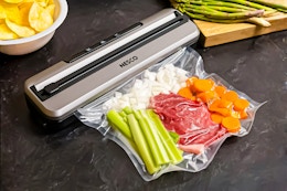 Nesco Vacuum Sealer Machine (lifestyle image) of it being used to seal produce