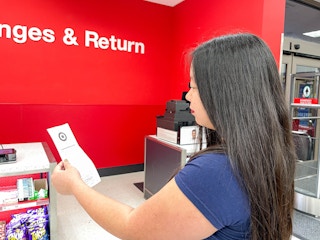 a woman holding a recepit standing in line at the target returns