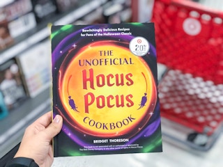 hand holding a hocus pocus cookbook at target