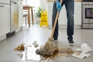a man mopping up oil in a kitchen