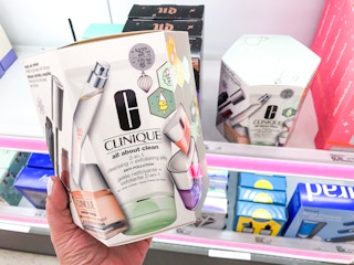 Someone holding a Clinique Ulta Exclusive Blockbuster Set in front of a shelf at Target