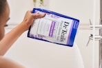 person pouring a bag of dr teals epsom salt soak