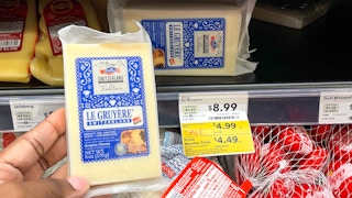 cheese hand held near sale sign at whole foods