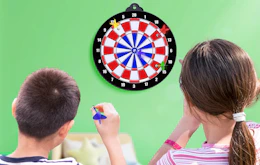 two kids throwing darts at a dart board 