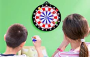 two kids throwing darts at a dart board