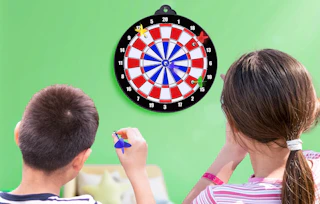 two kids throwing darts at a dart board
