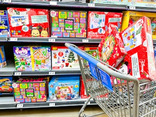 two boxes of advent calendars in walmart cart in front of advents on shelves
